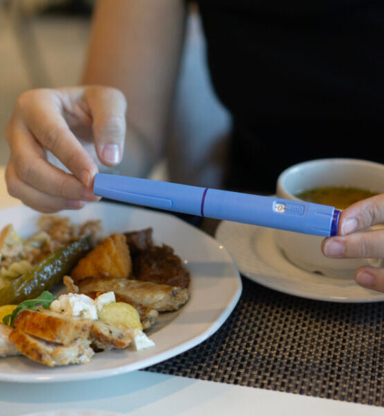 Close-up of a man administering a GLP-1 subcutaneous injection into his abdomen at home. Medical concept for diabetes management, obesity treatment, and weight loss medication.